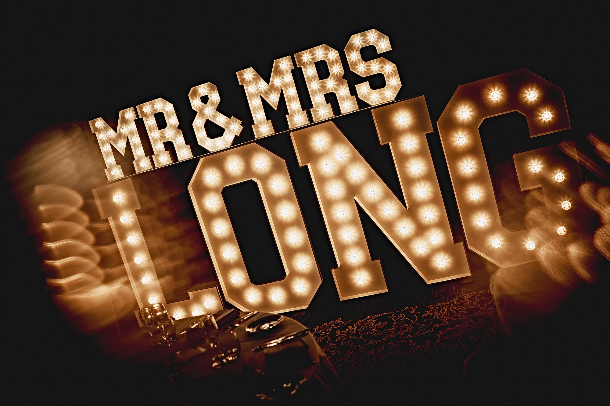 MR & MRS followed by surname in large illuminated letters, creating a glowing personalised display for a wedding reception and dancefloor.