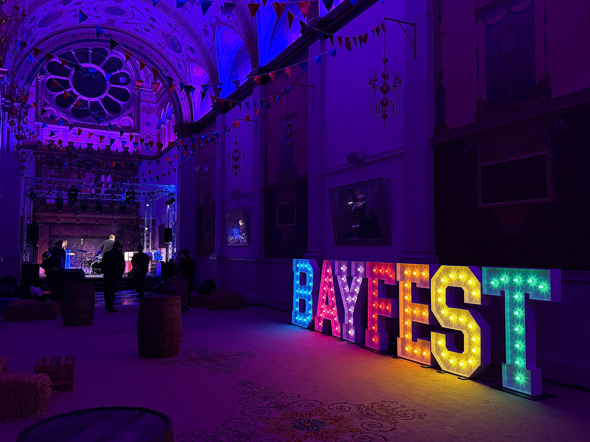 BAYFEST giant illuminated marquee letters at De Vere Windsor corporate event — purple uplighting