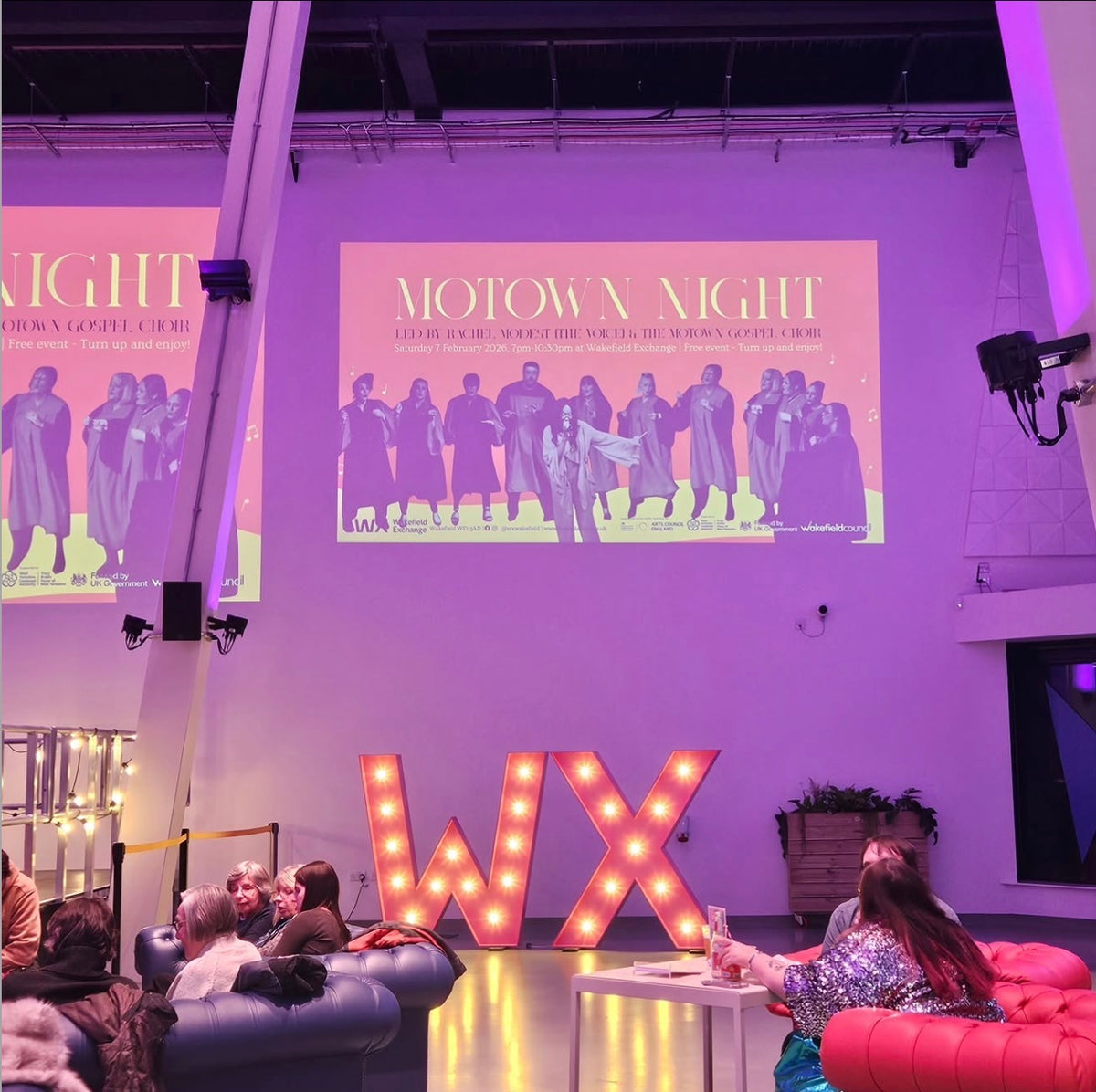 Event space with 'Motown Night' projection and 'WX' letter lights.