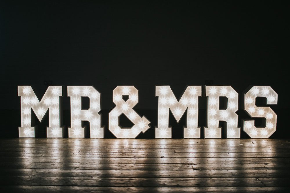 Large illuminated MR & MRS light up letters with warm white LEDs on a wooden floor, perfect for weddings and receptions.