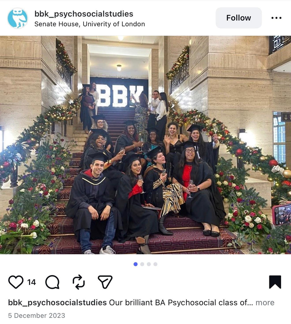 Graduates posing on a decorated staircase with 'BBK' signage in the background