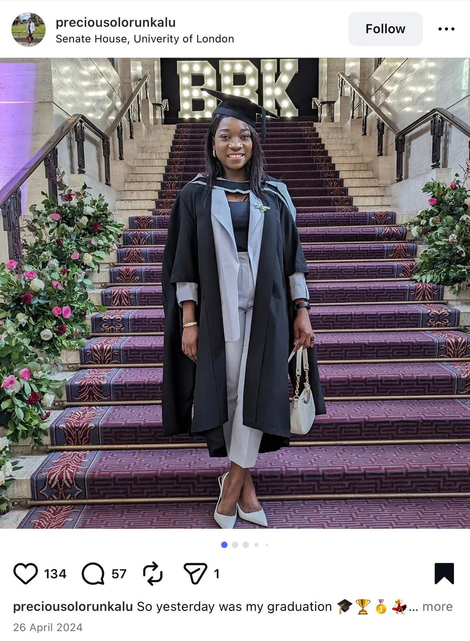 Graduate posing on a staircase with decorative steps and floral arrangements at Senate House, University of London.